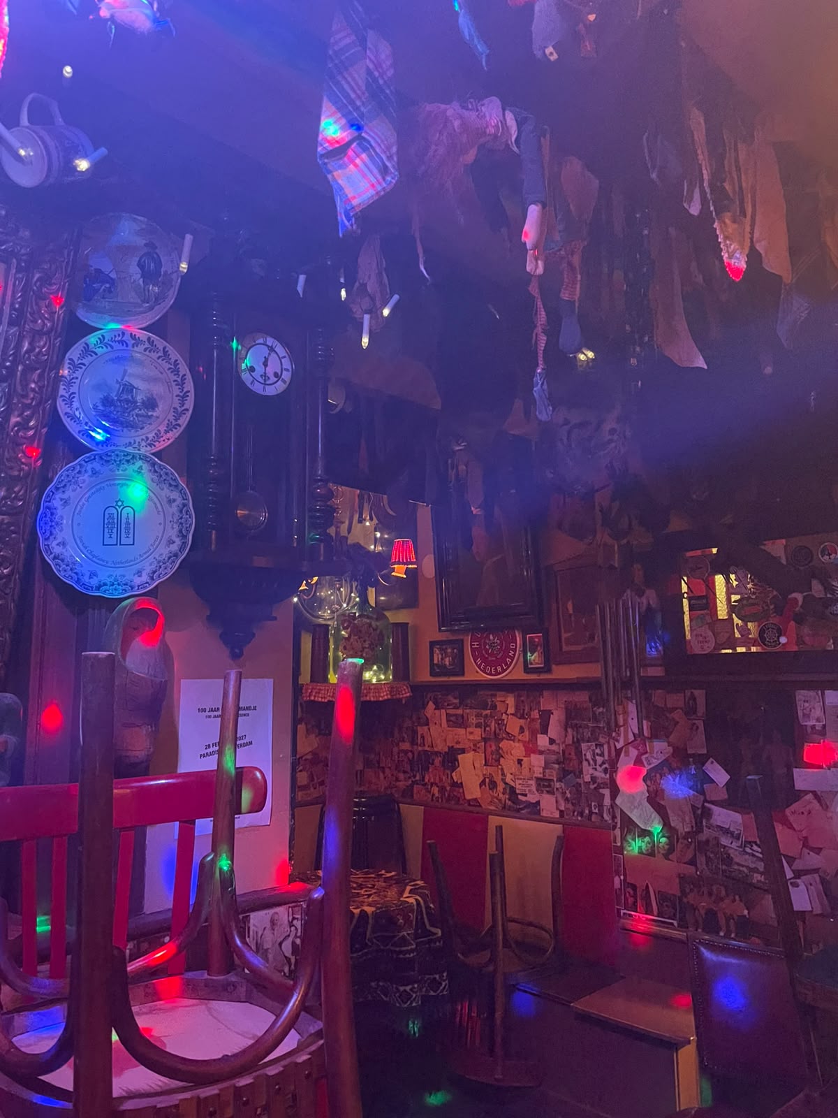Interior of Café 't Mandje, full of Delft plates, photos, ties hanging from the ceiling and disco lights