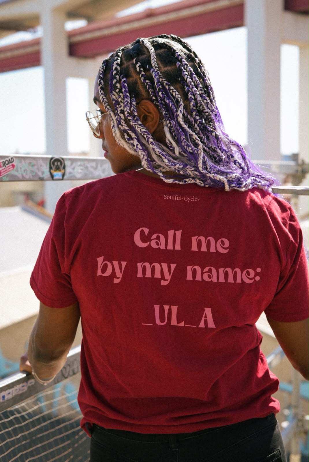 Back of a red t-shirt printed 'Call me by my name: _UL_A'