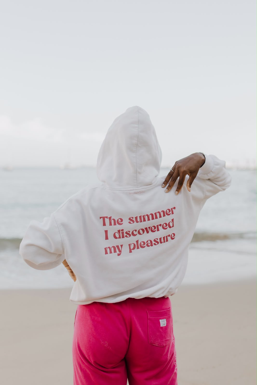 Back of a white hoodie printed 'The summer I discovered my pleasure'