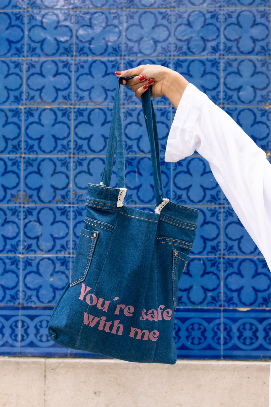 Denim tote bag printed 'You're safe with me' against blue tiles