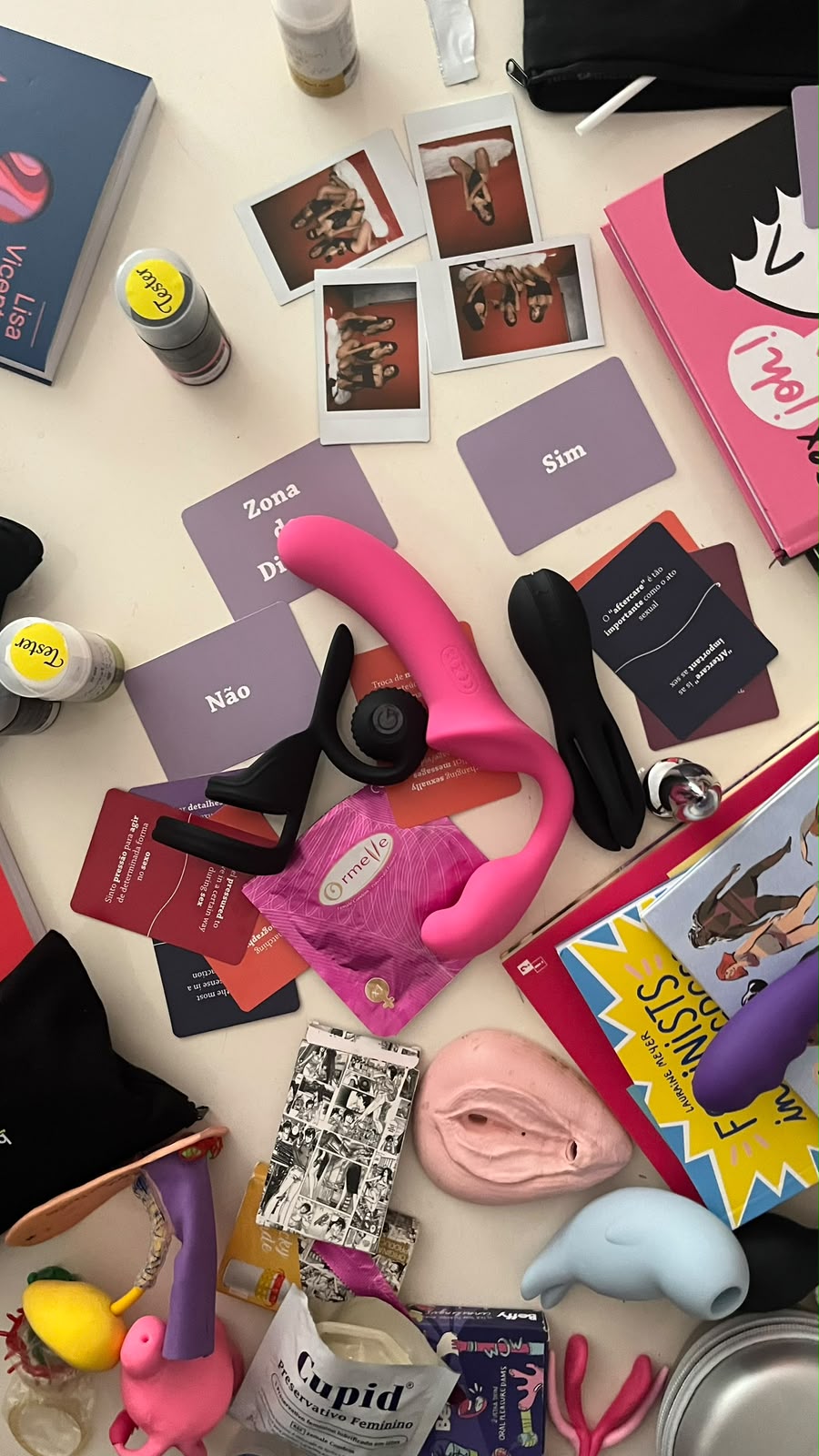 Table covered with sex toys, conversation cards, books, lubricant testers and condoms