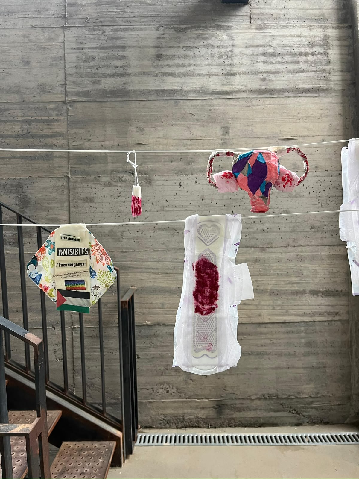 Clothesline exhibition of decorated pads, a tampon and a paper uterus